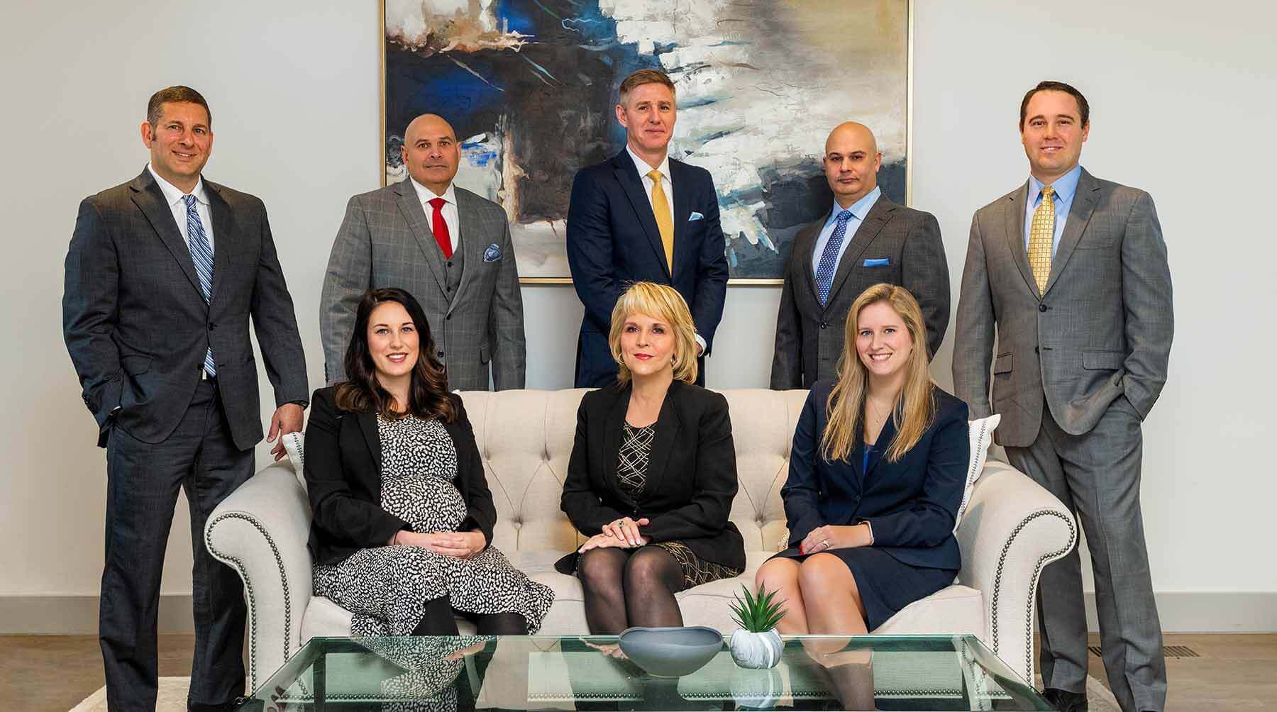 Group of lawyers posing for photo on couch