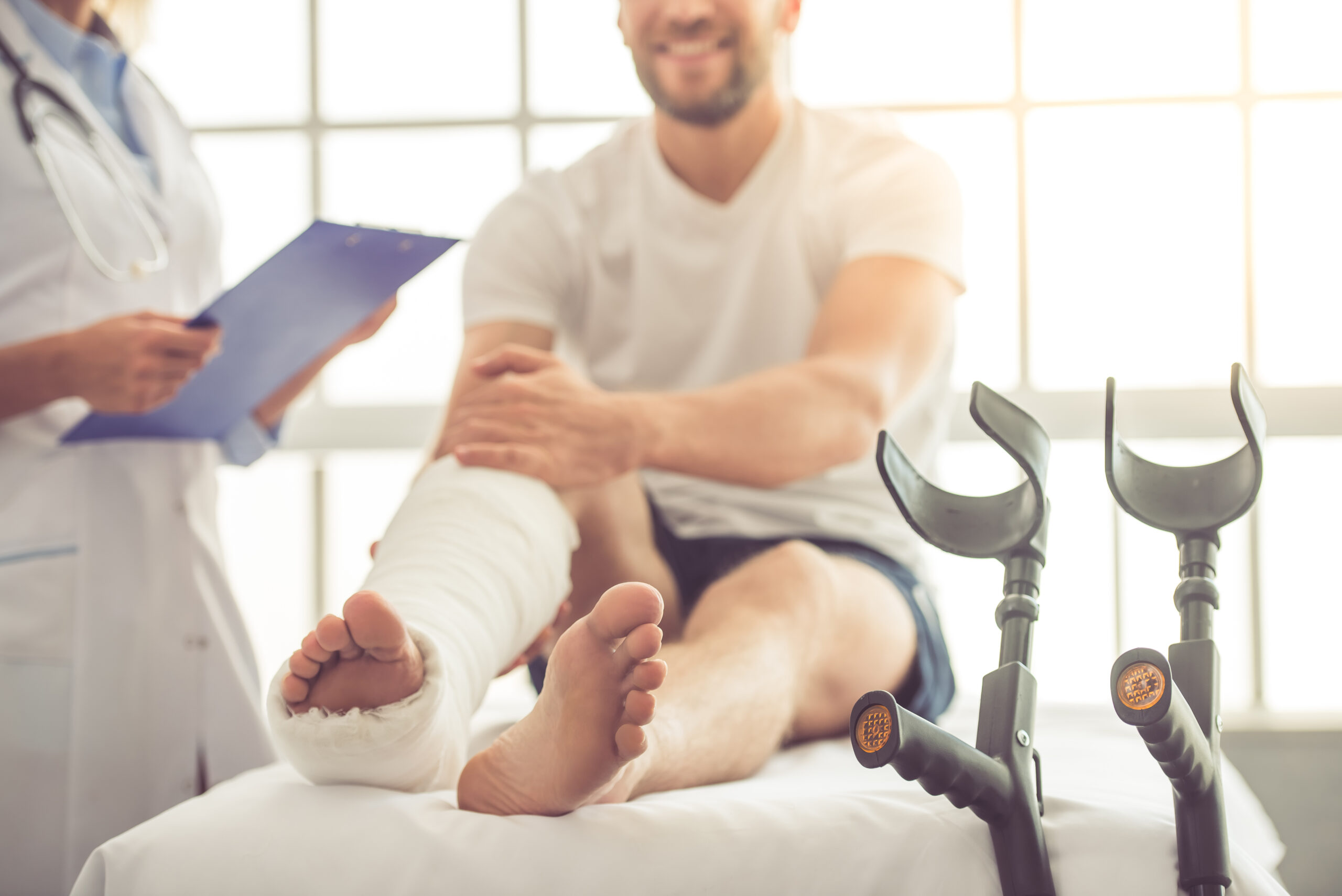 Man in leg cast with doctor next to him